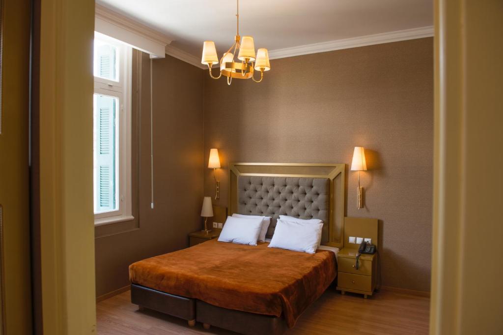 a bedroom with a bed and a chandelier at Delphi Art Hotel in Athens