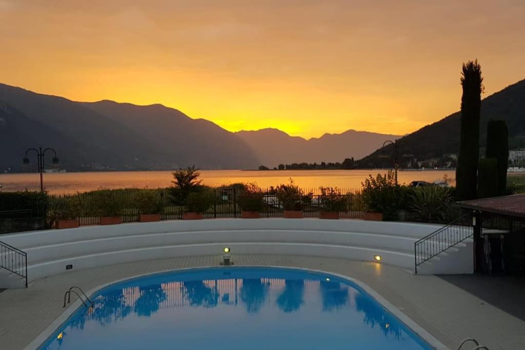a swimming pool with a sunset in the background at Copelia - Pool and Elegance in Paratico
