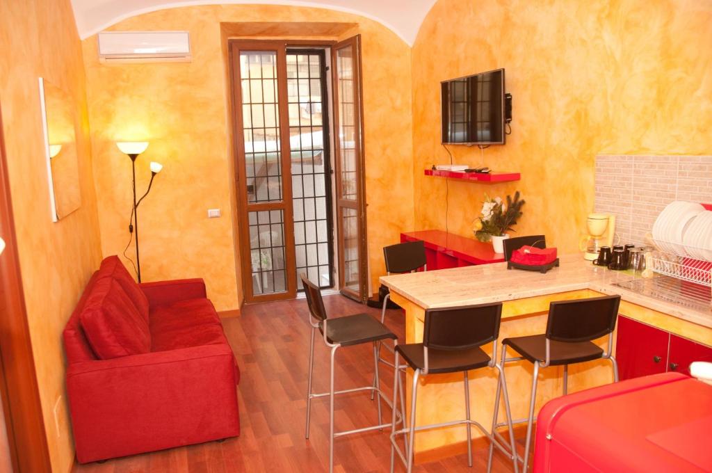 ローマにあるLucky Domus Esquilinoのリビングルーム(赤いソファ、テーブル付)