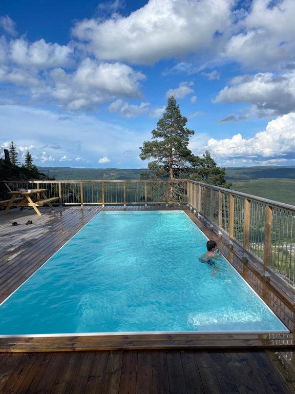 a child swimming in a swimming pool on a deck at Brand new mountain cabin in Branäs
