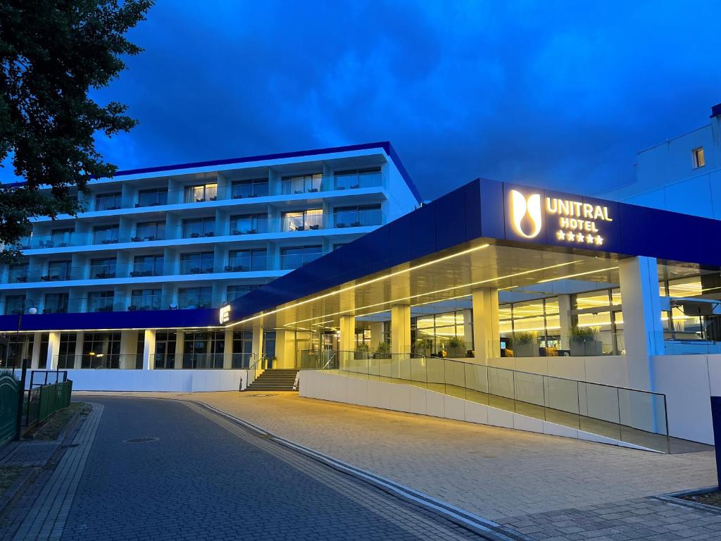 a building with a sign on the front of it at Hotel Wellness Medical Spa Unitral in Mielno