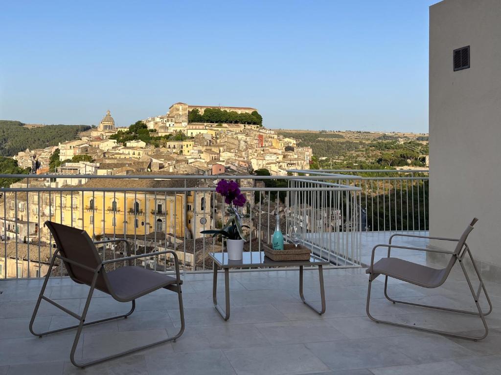 a balcony with two chairs and a table with a view at La casa di Irene - Suites con vista in Ragusa
