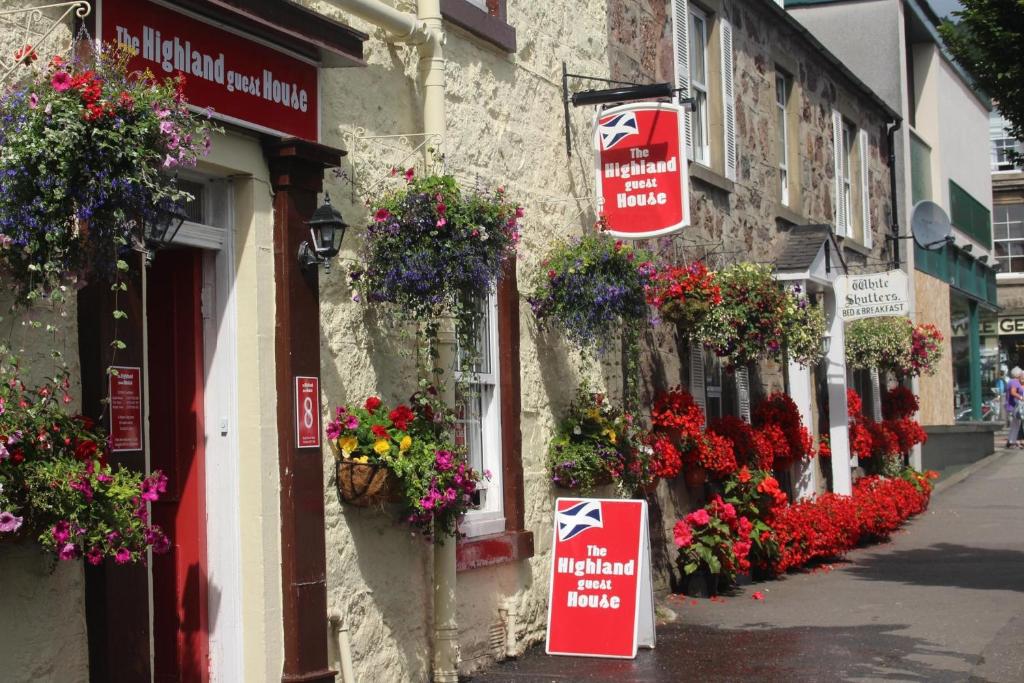 a street with flowers on the side of a building at Highland House Callander in Callander