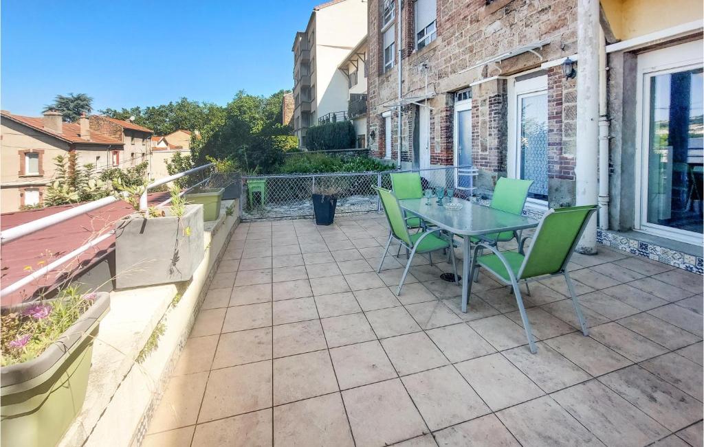a patio with a table and chairs on a balcony at Nice Apartment In Saint-tienne With Kitchen in Saint-Étienne