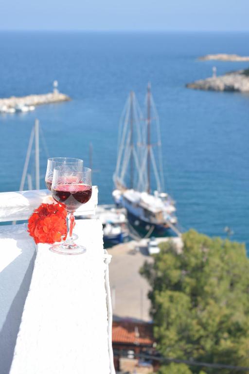 a glass of wine on a ledge with boats in the water at Studios Soula in Alonnisos