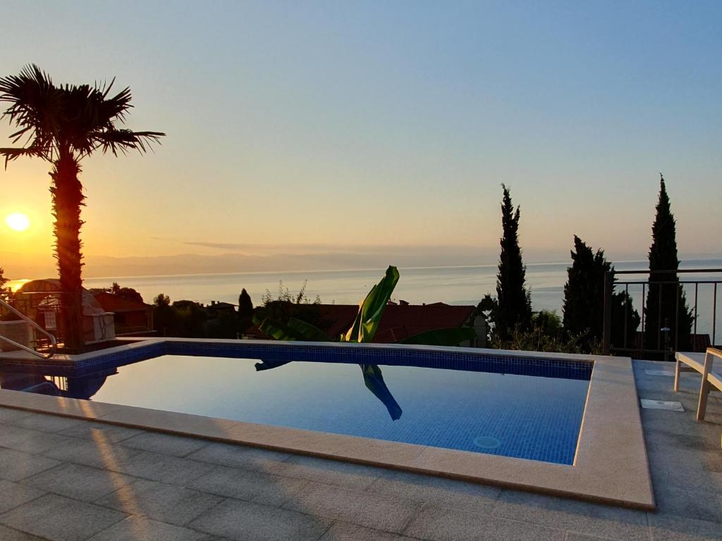 einen Pool in einer Villa mit Sonnenuntergang in der Unterkunft Villa Nikolla in Lovran