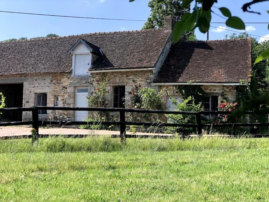 a stone house with a fence in front of it at La Petite Maison Dans la Nature in Forges