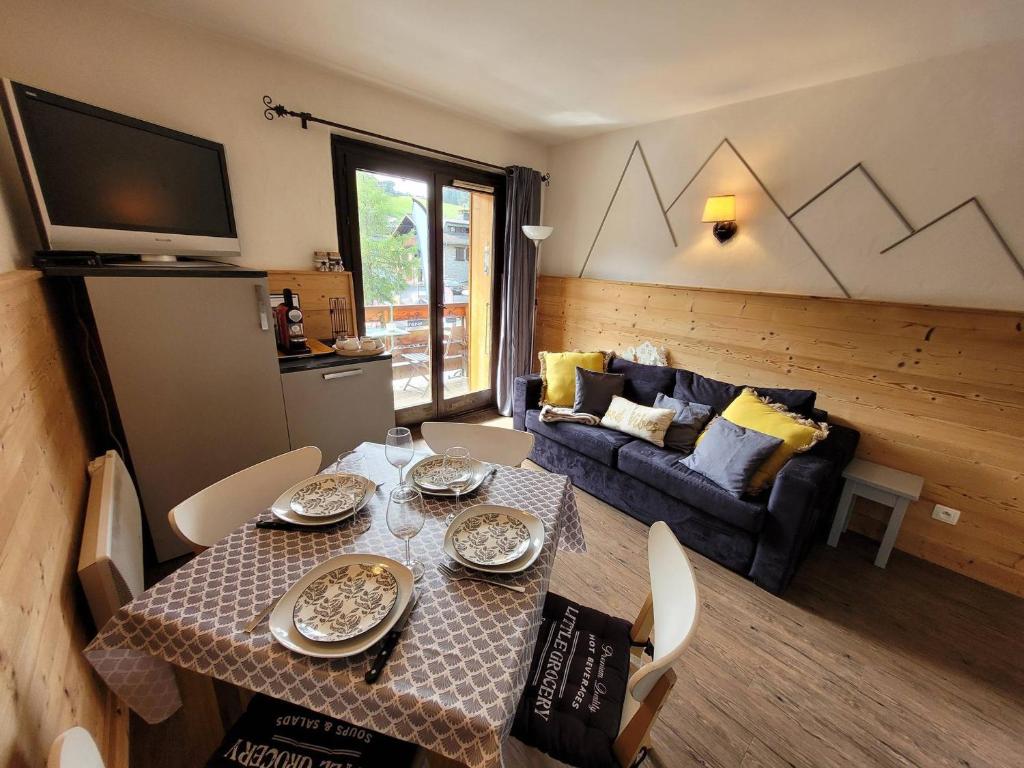 a living room with a table and a couch at Appartement Les Gets, 2 pièces, 4 personnes - FR-1-598-44 in Les Gets