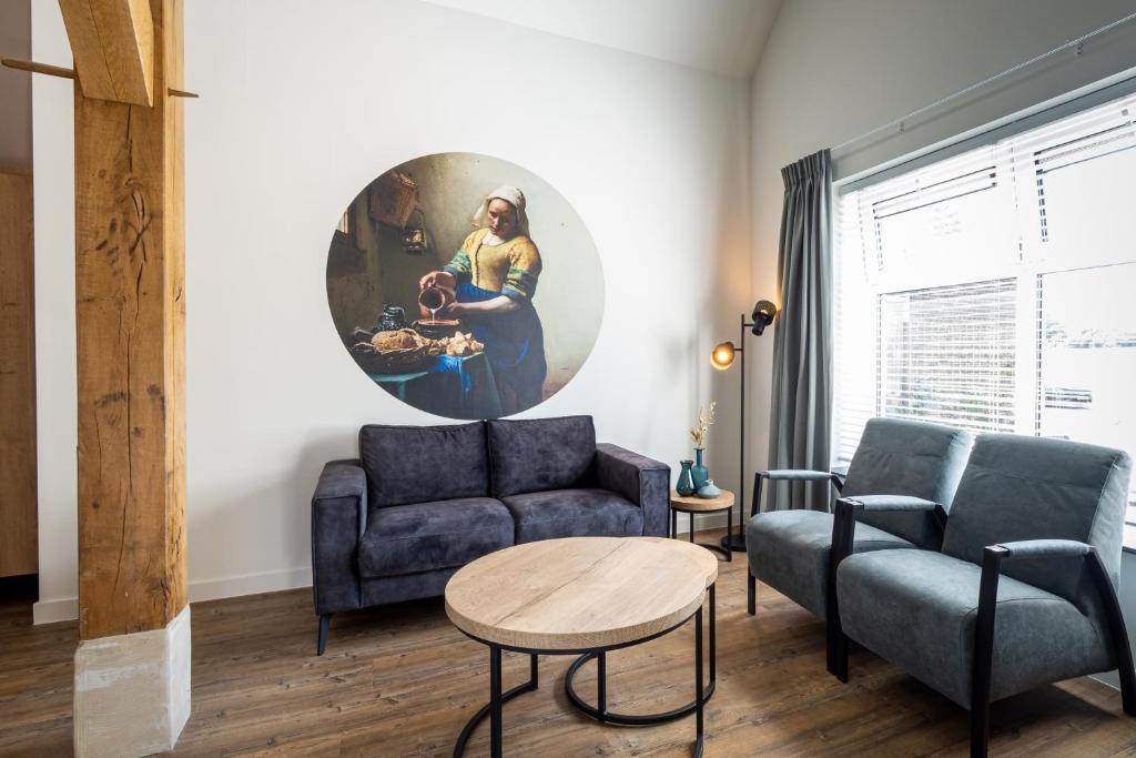 a living room with two couches and a table at Boerderijkamer 't Keukentje in Wijhe