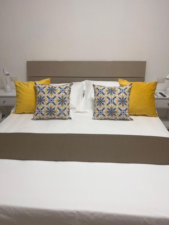 a bed with yellow and blue pillows on it at City Home 77 in Naples