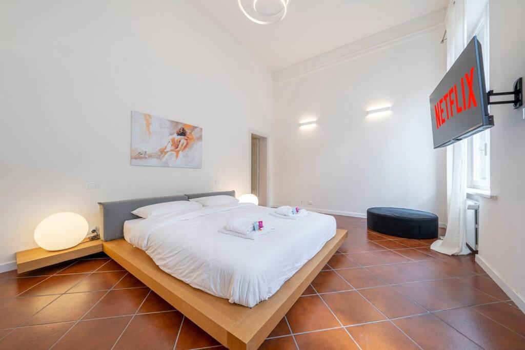 a bedroom with a white bed with a sign on the wall at PALAZZO DUCALE - Romantico appartamento in centro in Modena