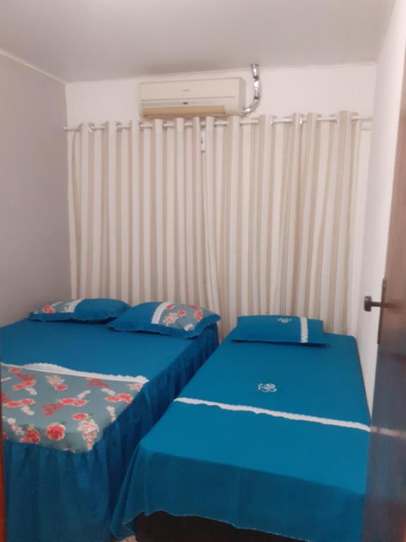 a bedroom with two beds with blue sheets at Cantinho da Biu in Maragogi