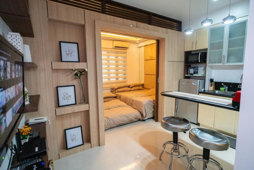 een klein appartement met een bed en twee krukken in een kamer bij A2J Executive Studio Near Venice Mall BGC Taguig in Manilla