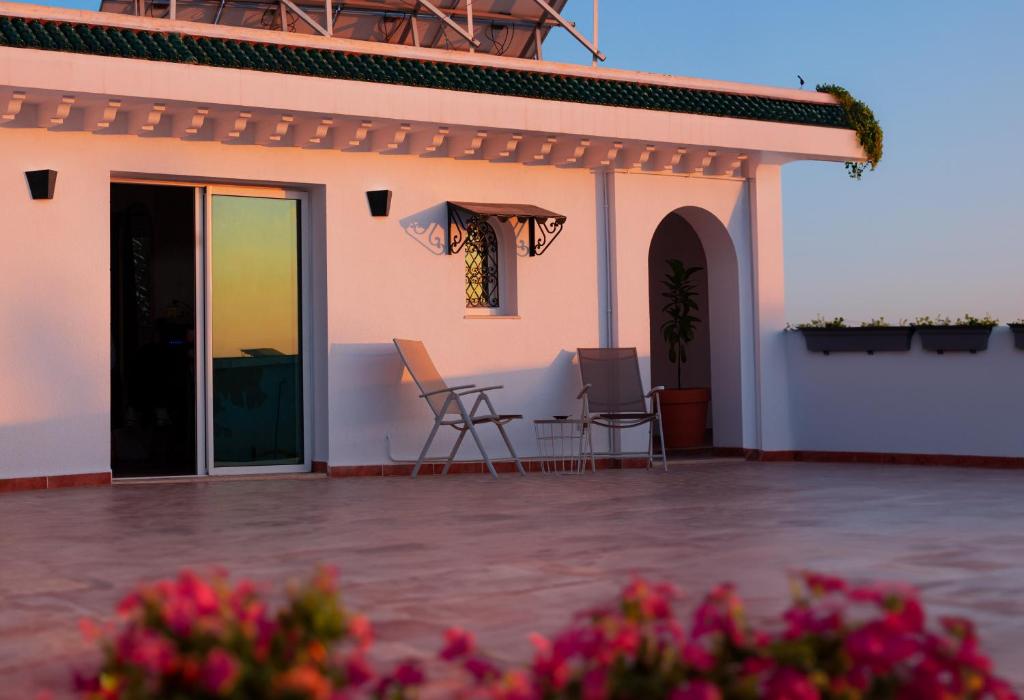 a house with a patio with chairs and a table at Cozy Studio with Rooftop Terrace & Cityscape Views in Le Bardo