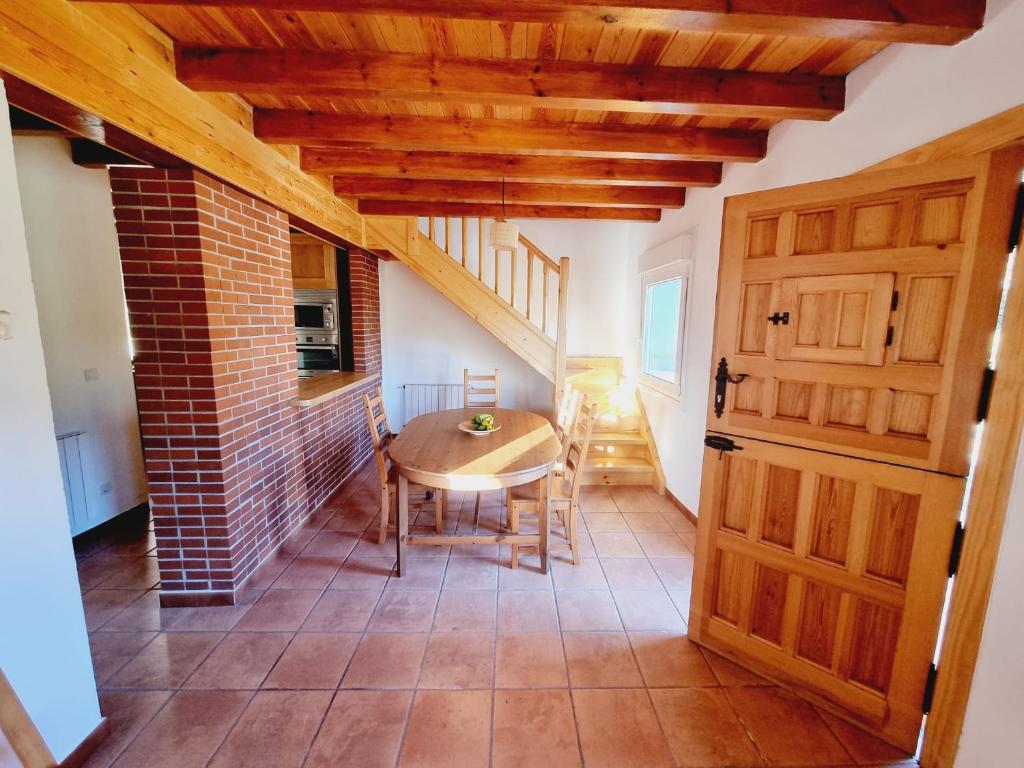 a dining room with a table and a brick wall at Casa Rural Villapresente in Reocín