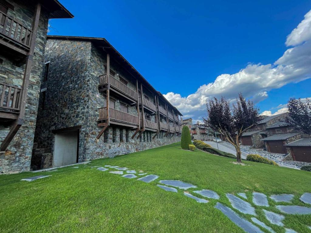 a building with a grass yard next to a building at Casa Elegancia Pleta de Saga in Ger