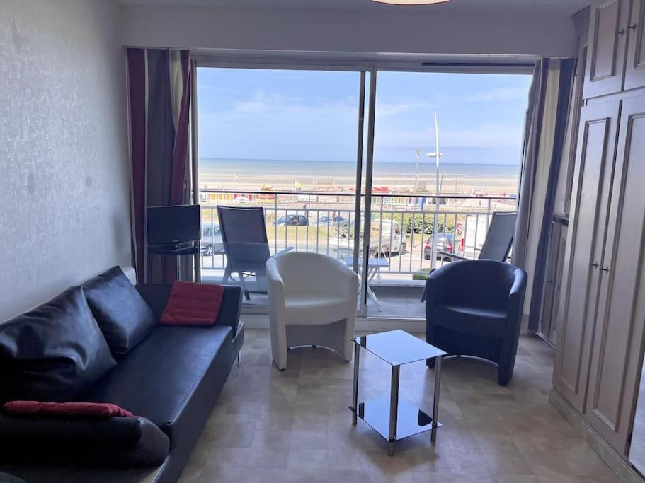 un salon avec un canapé et une vue sur l'océan dans l'établissement La Potinière studio face Mer, à Le Touquet-Paris-Plage