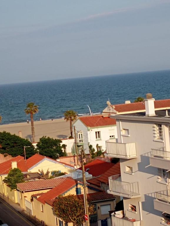 un groupe de bâtiments avec l'océan en arrière-plan dans l'établissement Location appartement bord de mer, à Canet