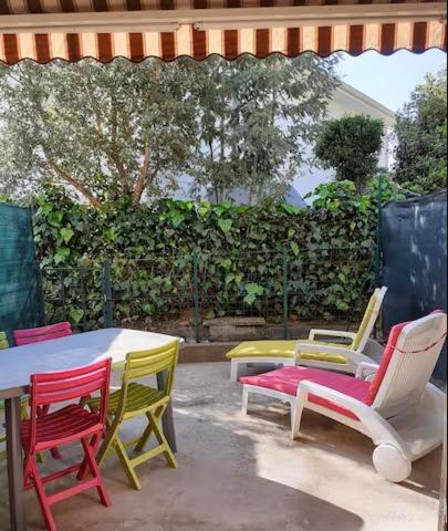 - un ensemble de chaises et de tables colorées sur une terrasse dans l'établissement Charmant T2, quartier résidentiel calme, St Aygulf, à Fréjus