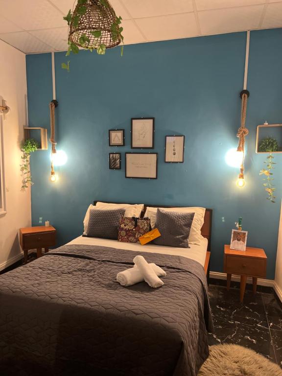 1 dormitorio con 1 cama grande y pared azul en Bel appartement avec petit balcon sympa, en Porto Novo