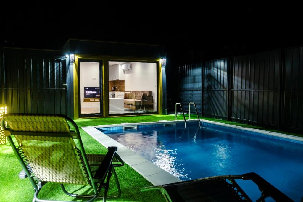 ein Schwimmbad bei Nacht mit einem Stuhl daneben in der Unterkunft MILUX in Sanski most