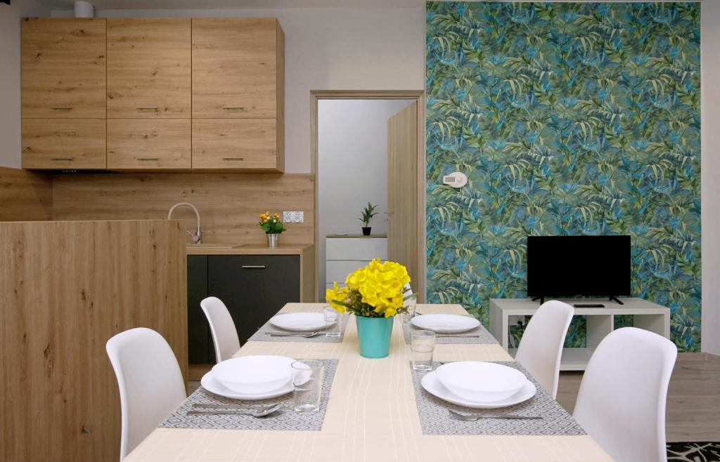 a dining room with a table and white chairs at Apartament Piwna 13 in Gliwice