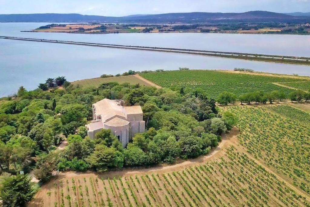 una vista aérea de una casa en una colina junto a un lago en Maison sud de France avec jacuzzi et sauna privé, en Villeneuve-lès-Maguelonne