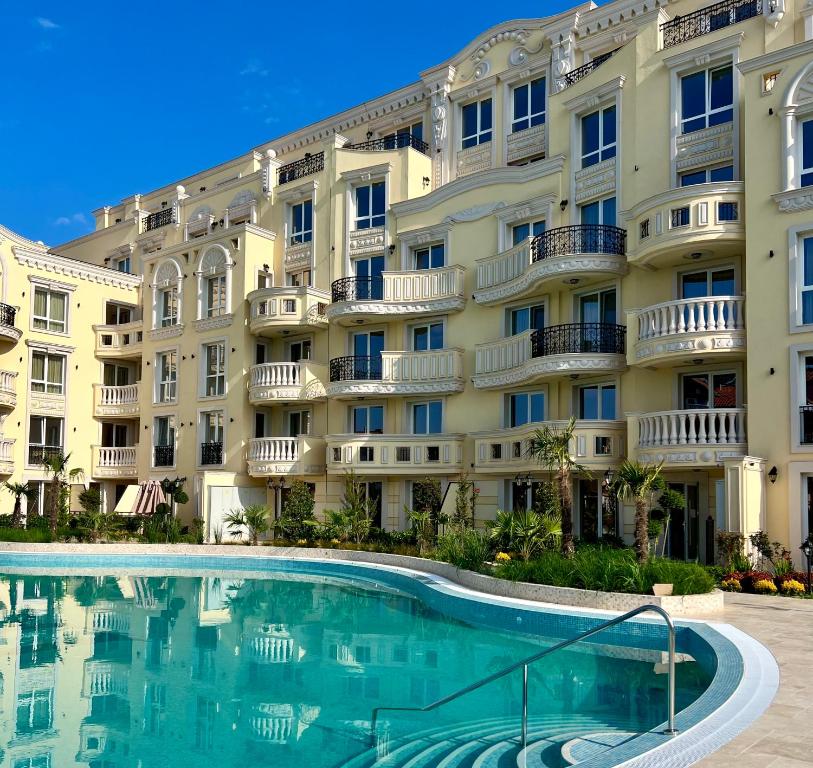 a hotel with a swimming pool in front of a building at Sunny apartment in Bellicity complex in Ravda