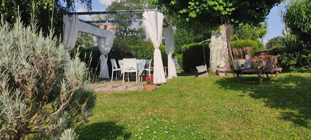 a garden with a table and a pergola at Respire O'Dorat chambres privées dans havre de paix in Le Dorat
