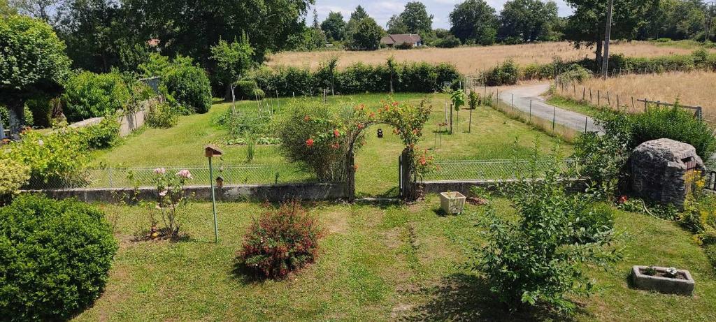 an outdoor garden with fruit trees and a fence at Respire O&#39;Dorat chambres privées dans havre de paix in Le Dorat