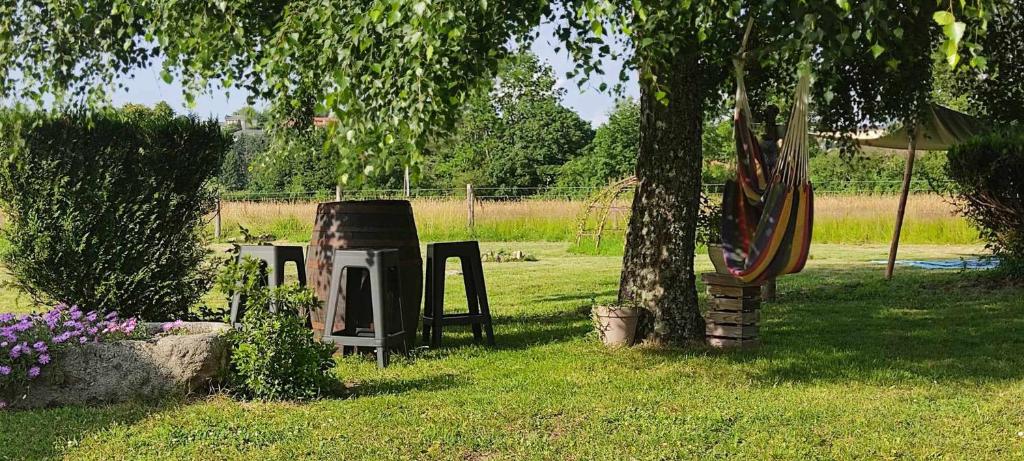 a garden with a tree and an old stove at Respire O&#39;Dorat chambres privées dans havre de paix in Le Dorat