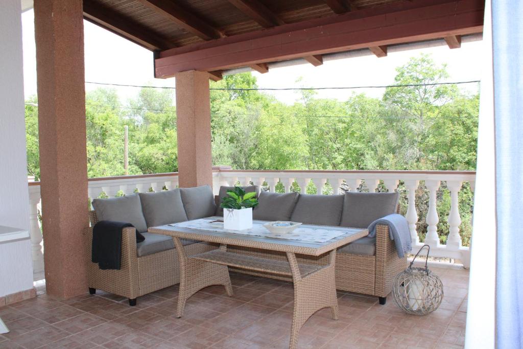 patio ze stołem i krzesłami na ganku w obiekcie Apartment Noel w mieście Sveti Vid-Miholjice