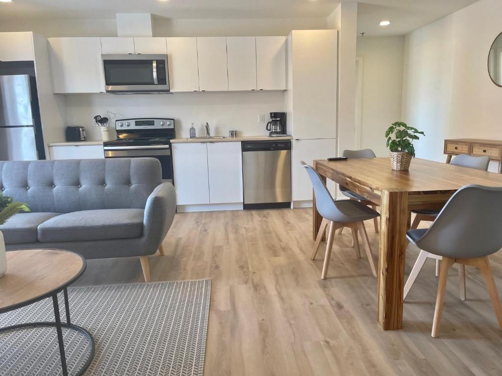 een keuken en een woonkamer met een tafel en stoelen bij APPART-HOTEL L'UNI in Québec