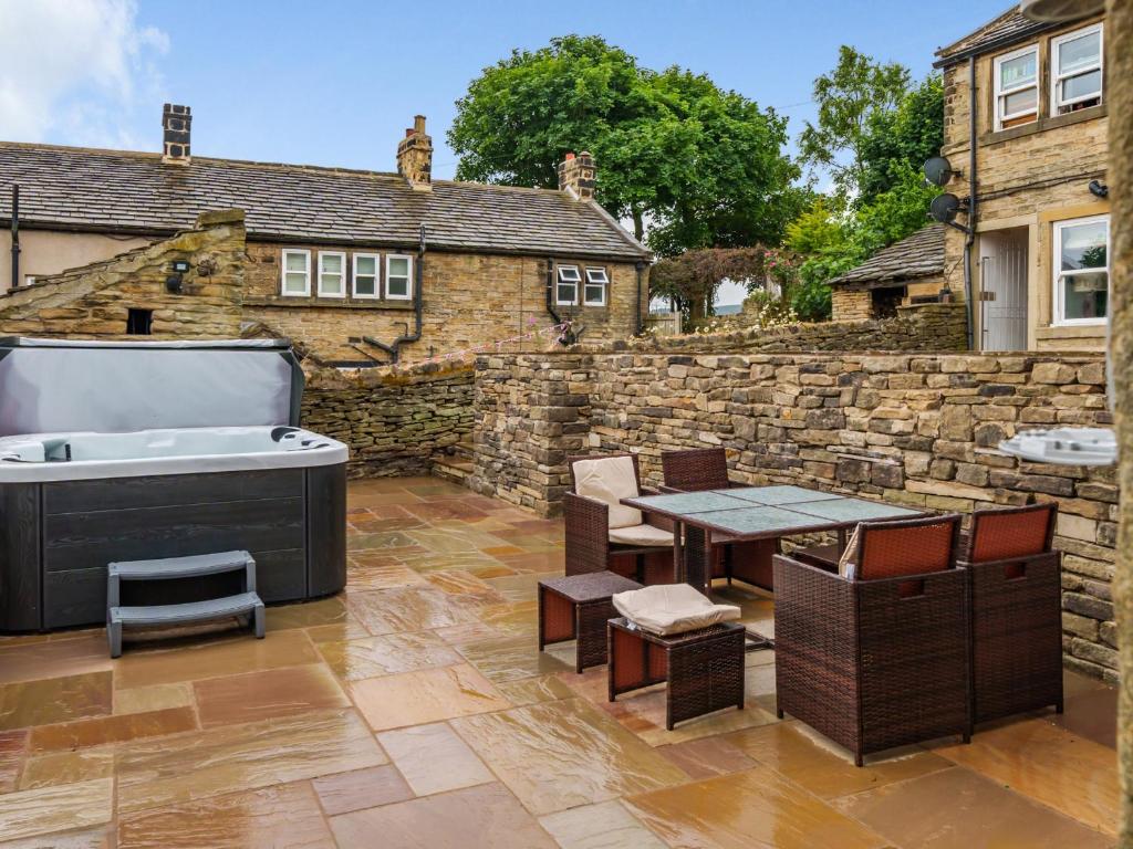 a backyard with a hot tub and a table and chairs at The Barn in Holmfirth