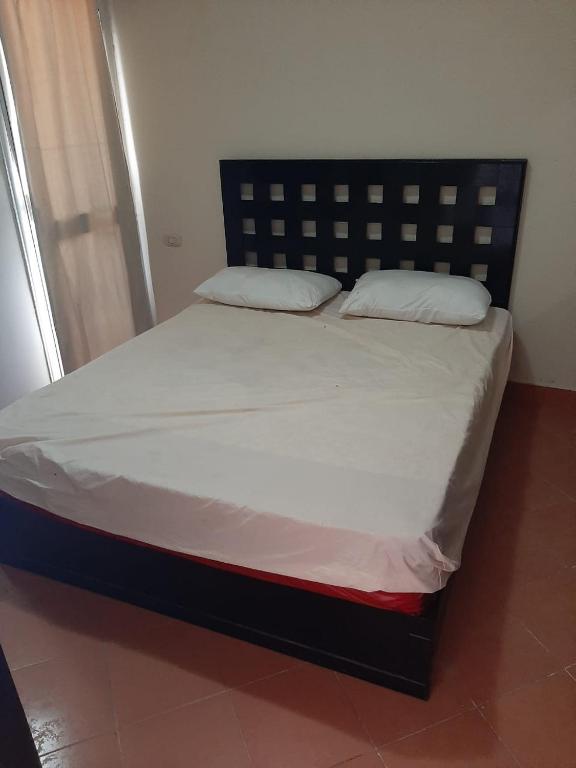 A bed or beds in a room at Porto Residence Chalet, Outside Marina Gate 3, Sahel North Coast For Rent - شاليه بورتورسيدنس بخارج بوابة 3 مارينا الساحل الإيجار
