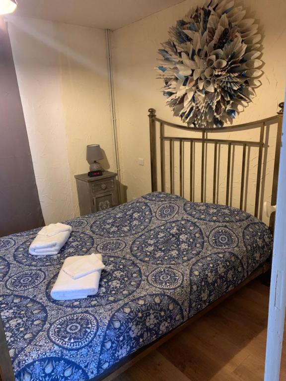 ein Schlafzimmer mit einem Bett mit zwei Handtüchern darauf in der Unterkunft La Canourguette in La Canourgue