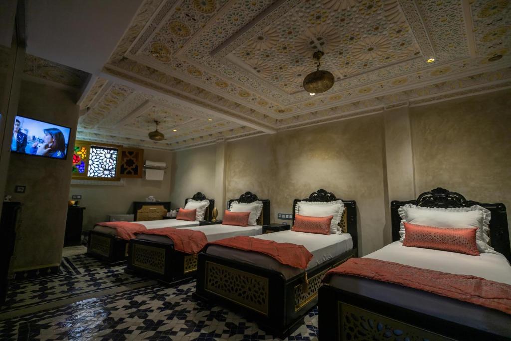 A bed or beds in a room at Hotel & Ryad DALILA