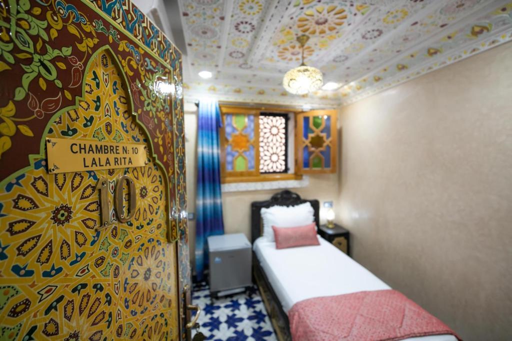 A bed or beds in a room at Hotel & Ryad DALILA