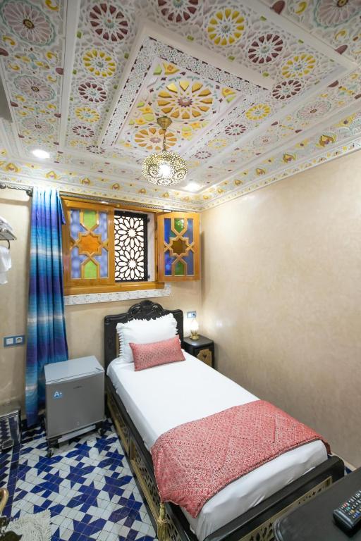 A bed or beds in a room at Hotel & Ryad DALILA