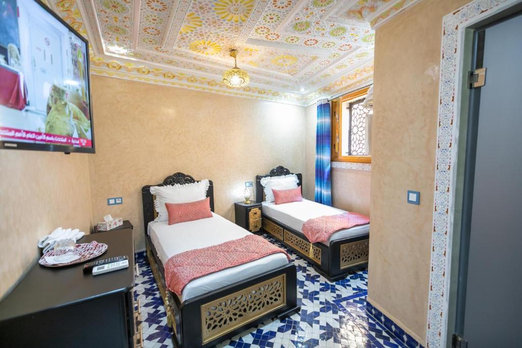 A bed or beds in a room at Hotel & Ryad DALILA