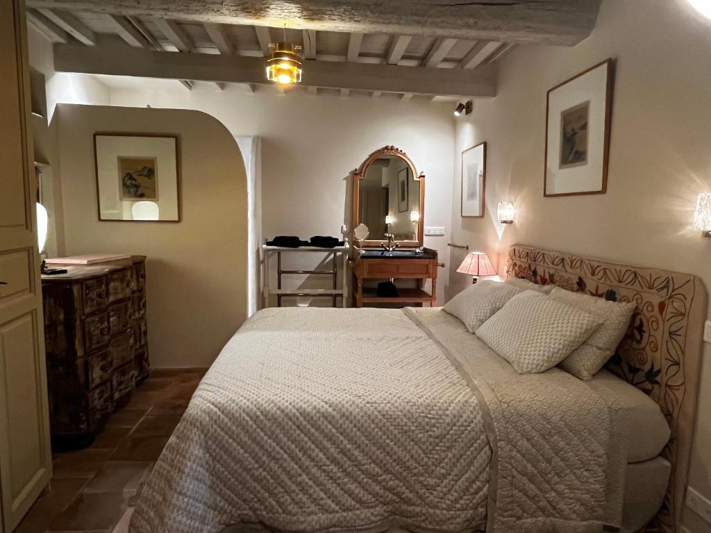 um quarto com uma cama, um toucador e um espelho. em La Maison de Fabienne em Tarascon