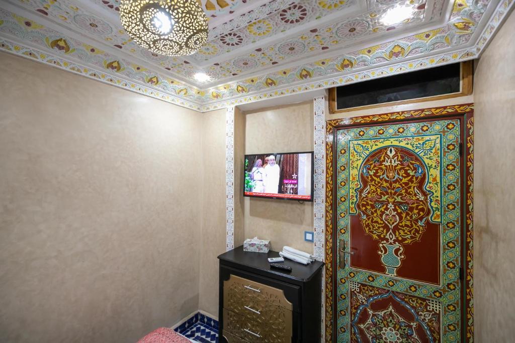 A television and/or entertainment centre at Hotel & Ryad DALILA