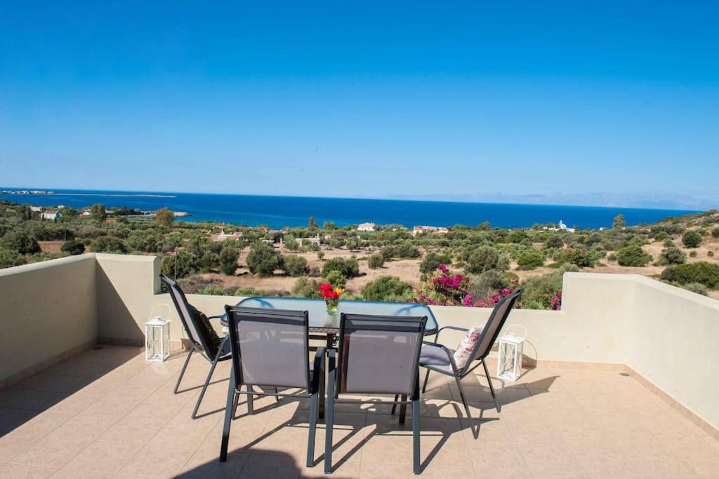 a table and chairs on a balcony with the ocean at Villa Pyla in Paralia Demonias