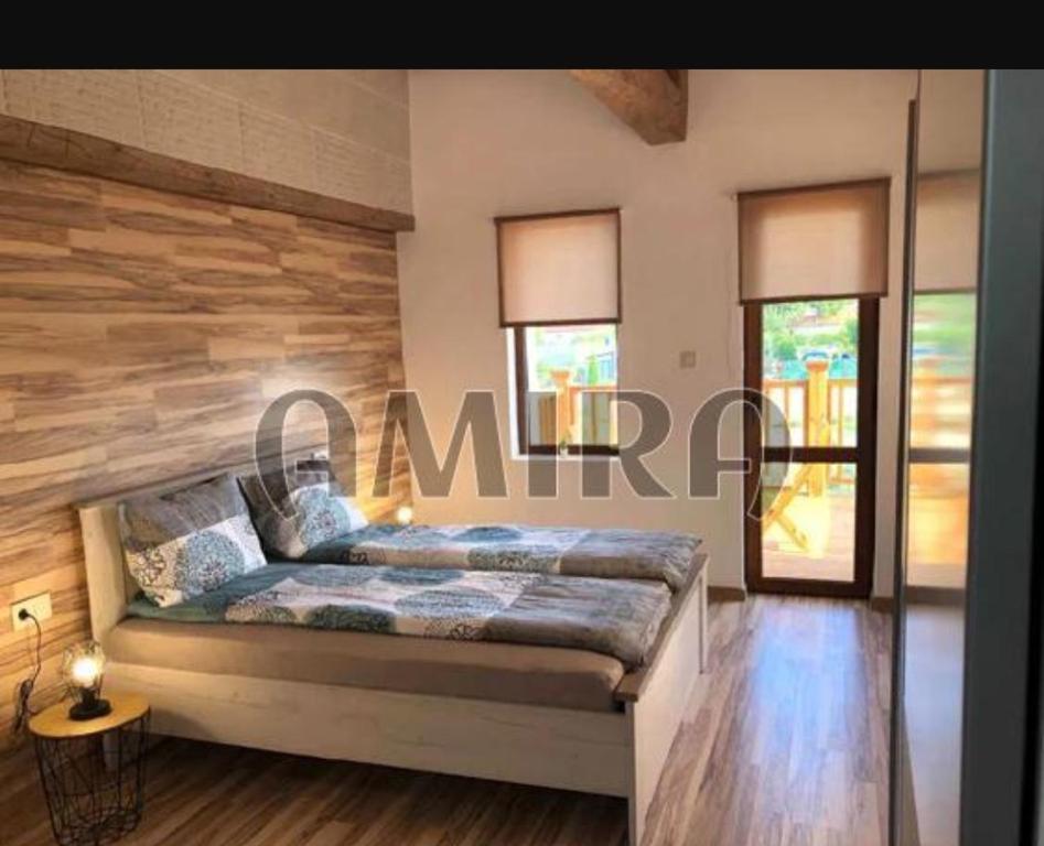 a bedroom with a bed with a wooden wall at Haus Tsarichino in Tsarichino