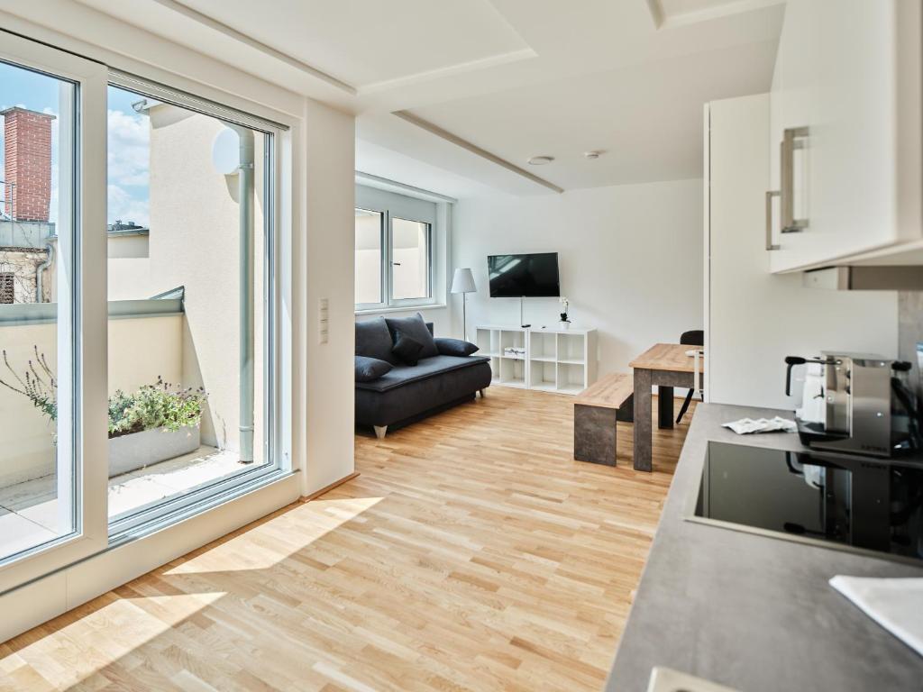 ein Wohnzimmer mit einem Sofa und einem großen Fenster in der Unterkunft MySchönbrunn Apartments in Wien