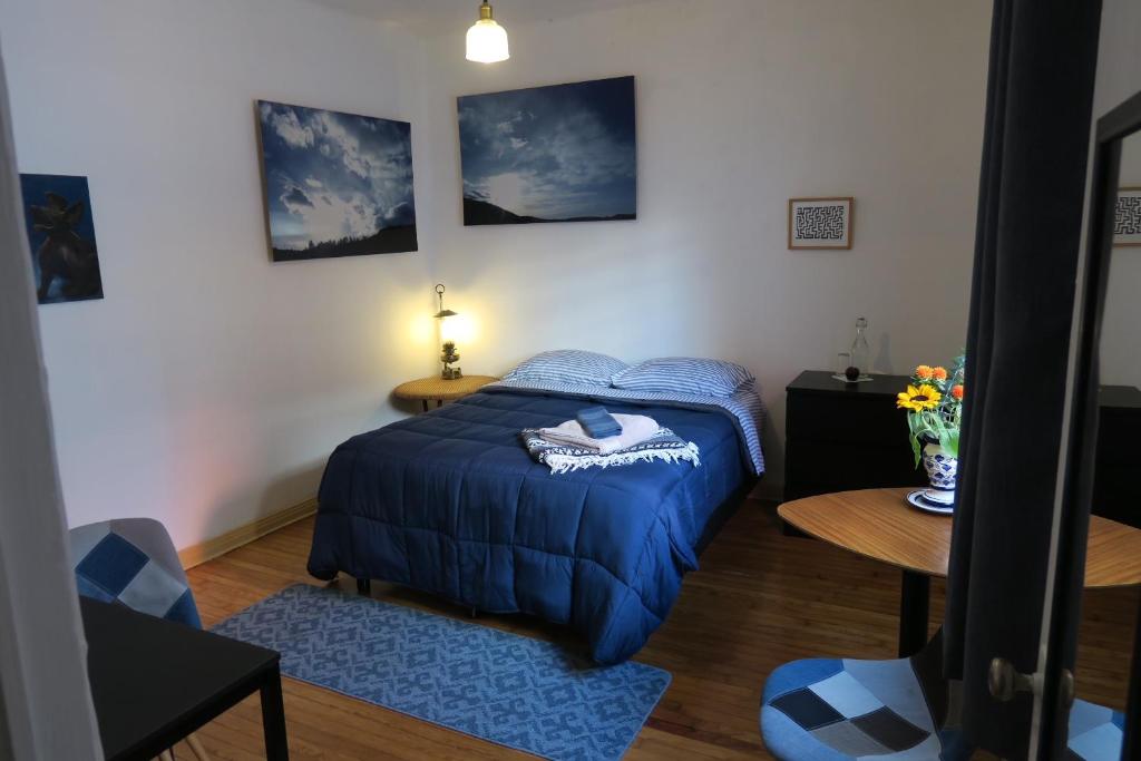 Un dormitorio con una cama azul y una mesa en Indigo Guest House en Ciudad de México