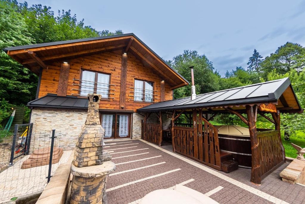 a log home with a hot tub and a gazebo at U Tadka dom z jacuzzi in Wisła