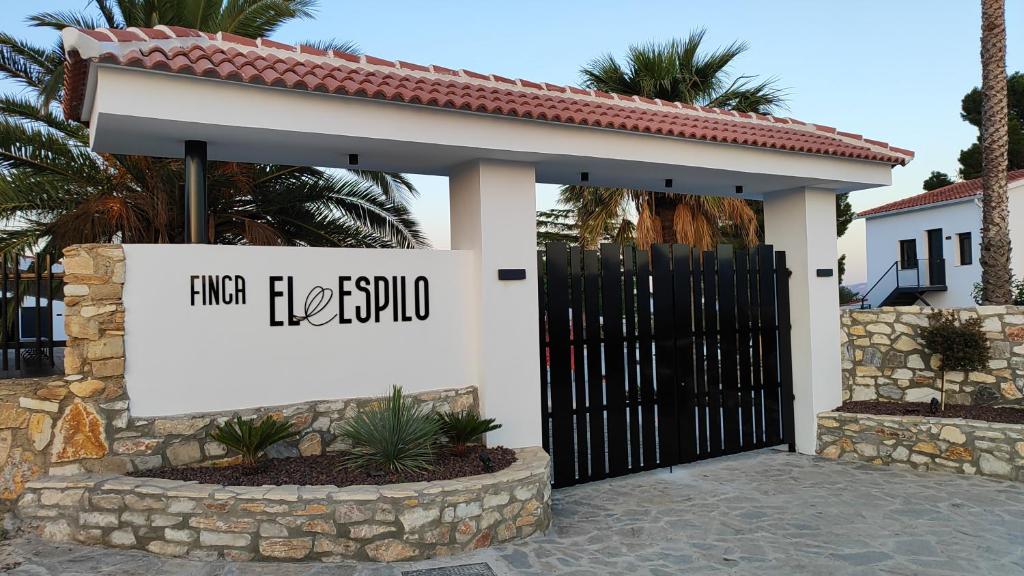 a sign in front of a house with a gate at Finca El Espilo in Lúcar