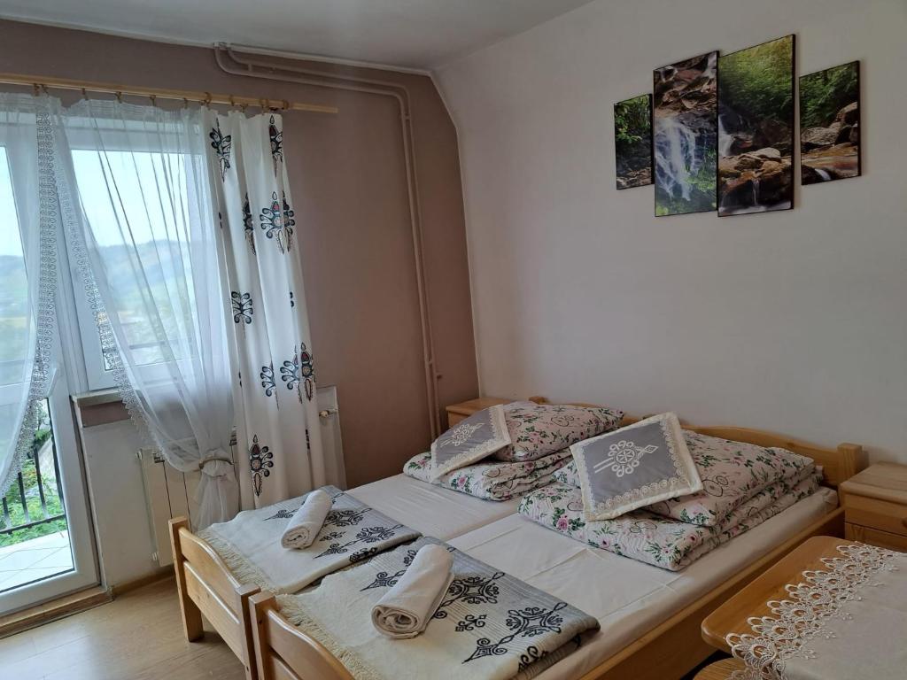Un dormitorio con dos camas individuales y una ventana. en Willa Grzesiczek, en Zakopane