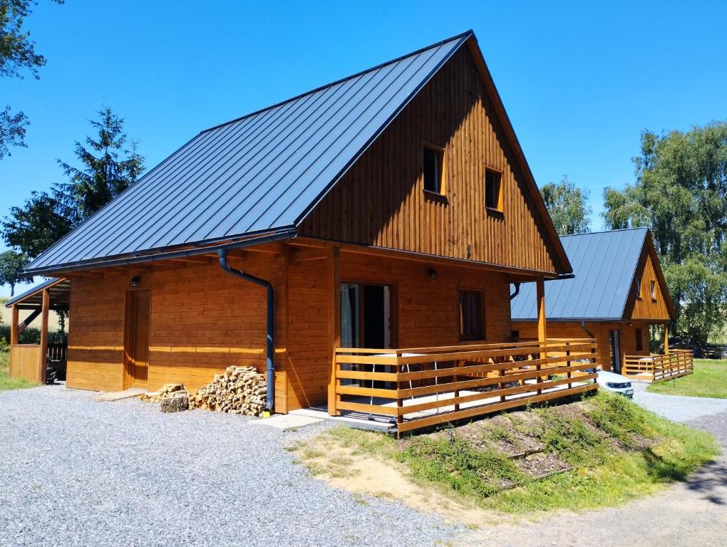 a large wooden cabin with a black roof at Chata u rybníka in Bohdalov